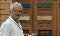 Imker vor Bienenkörben