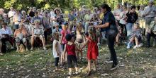 Kinder und Erwachsene singen auf der Wiese