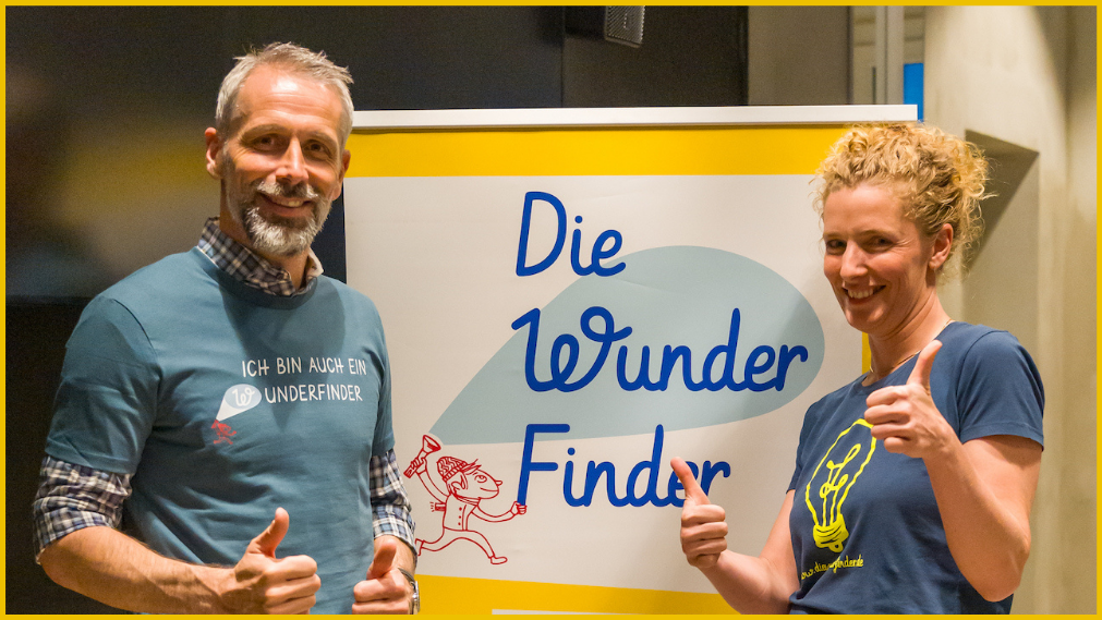 Trainer und Programmleiterin vor Wunderfinder-Logo