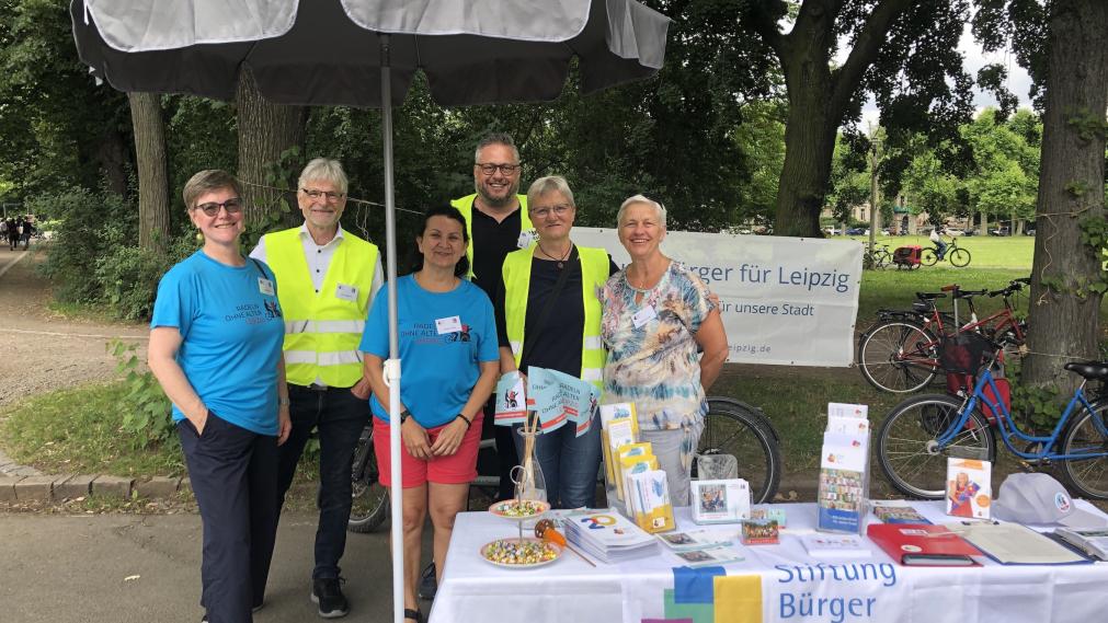 sechs personen am infostand im park