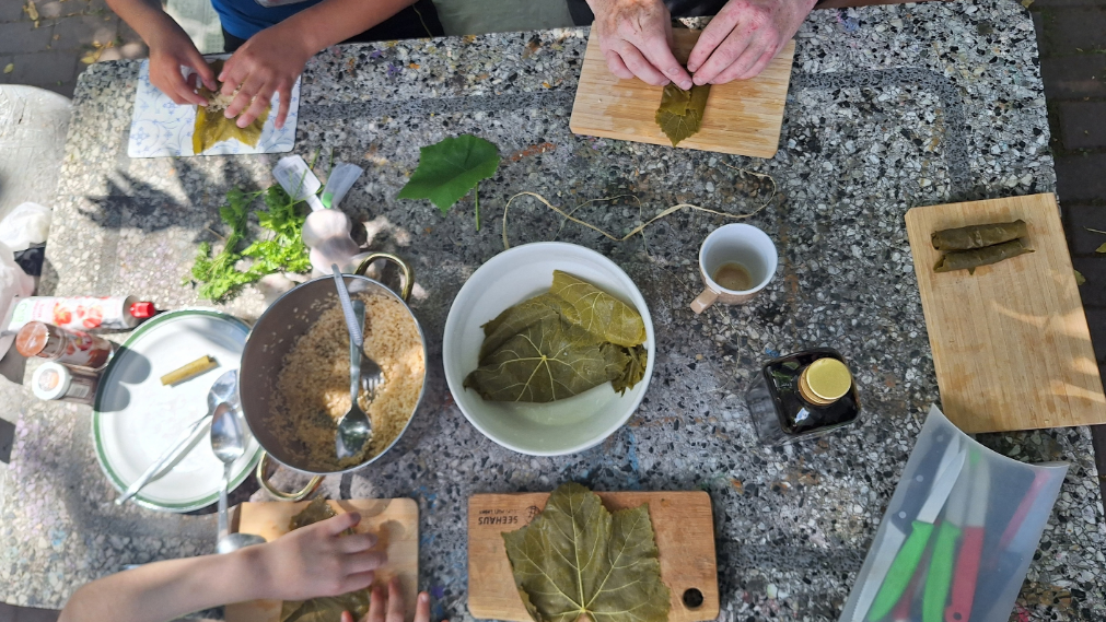 Tisch von oben mit Händen und Weinblättern